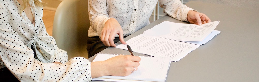 two people sitting at a table reviewing a resume